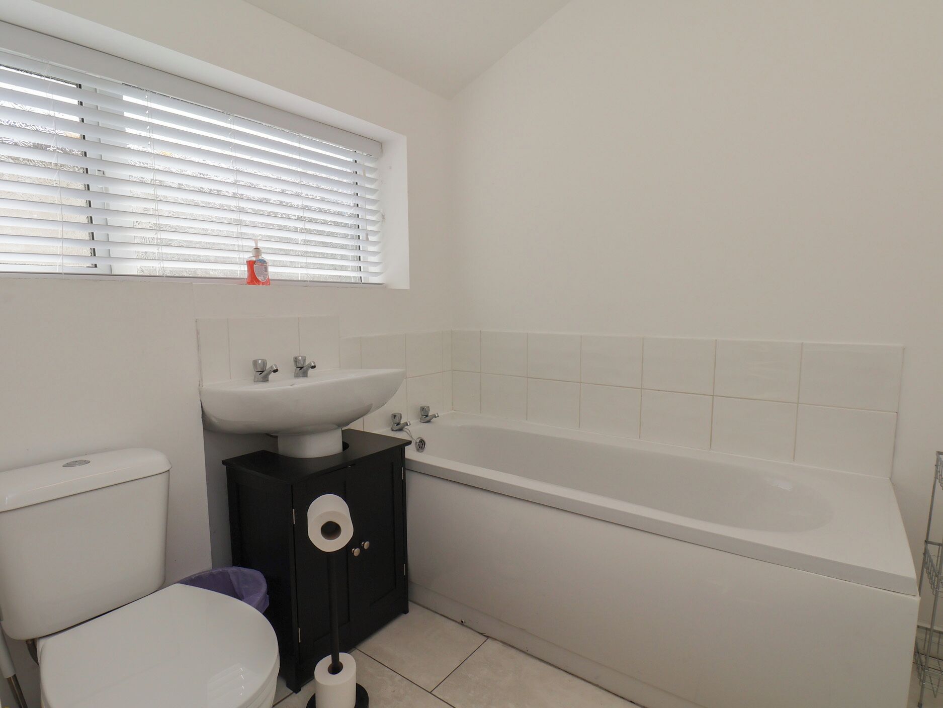 A bathroom with a toilet, sink, and bathtub.
