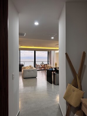 Ein modernes Interieur mit Sofa, Esstisch und Stühlen, Blick zum Himmel und einem großen Fenster.