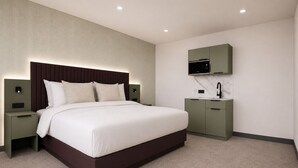 A modern hotel room with a large bed, bedside tables, a built-in TV, and a small kitchenette. - The View by BIDE Hotels (Thurso)