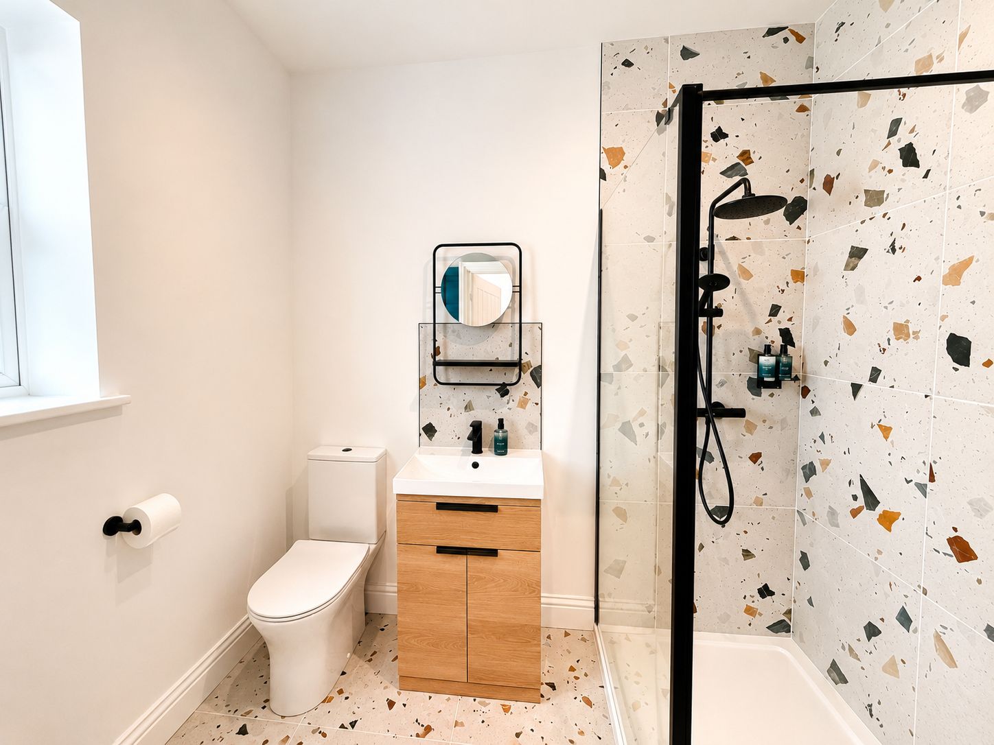 Un baño moderno con inodoro, lavamanos y ducha.