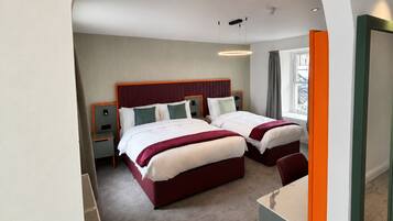 A hotel room with two beds, a large mirror, and a view of the outside.
