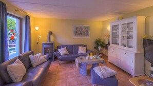 Ein Wohnzimmer mit einer Couch, einem Couchtisch, einem Schrank und einem Fernseher.