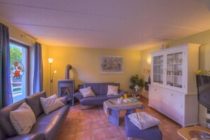 Ein Wohnzimmer mit einer Couch, einem Couchtisch, einem Schrank und einem Fernseher.