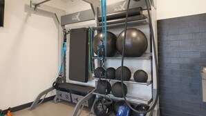 Ett gym med en stång för chins, viktskivor och en bänk.