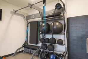 A gym with a pull-up bar, weight plates, and a bench. - Modern Studio Near Airport with Free Parking (Millcreek)