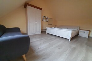 A bedroom with a bed, a wardrobe, a bedside table, and a chair. - Gemütliches Ferienhaus mit Terrasse nahe dem Müritzsee in Rechlin (Rechlin)