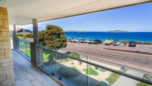 A balcony with a clear view of the ocean and parked vehicles. - West Beach House in West Beach (Esperance)
