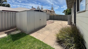 A residential backyard with a fenced area, a patio, and a house in the background. - Little Emily in Esperance (Esperance)