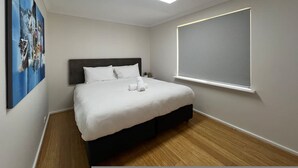 A bedroom with a bed, a ceiling light, a window, and a wall-mounted artwork. - Little Emily in Esperance (Esperance)