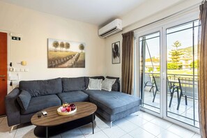 Ein modernes Wohnzimmer mit einem grauen Sofa, einem Holztisch und einem Baumgemälde.