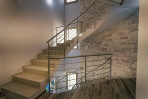 A staircase with a metal railing and a stone wall. - Villa Skyline: Design, Pool, Ocean View by Sicily Home Solutions (Castellammare del Golfo)