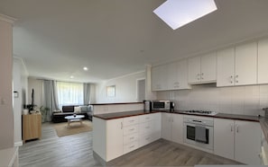 A modern kitchen with white cabinets, a microwave, and a stove. - Southern Comfort in Esperance (Esperance)