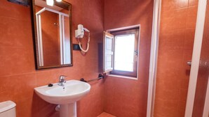 A bathroom with a white sink, a mirror, and a window. - La Juderia Segovia Lodging (Segovia)