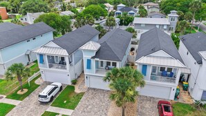 A residential area with houses featuring balconies, a paved driveway, and a parked car. - Sunny 3BR Getaway | Good Morning Rentals (Jacksonville Beach)