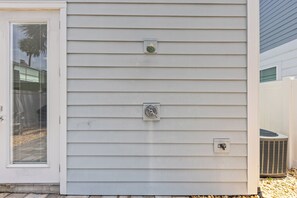 Ein Haus mit außenliegenden Stromkästen und einem Fenster mit Rollläden.