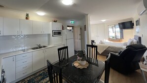 A compact living space with a kitchen, dining area, and a bedroom.