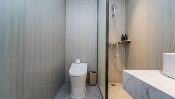 Habitación doble económica | Baño | Regadera, regadera tipo lluvia, amenidades de baño gratuitas, pantuflas