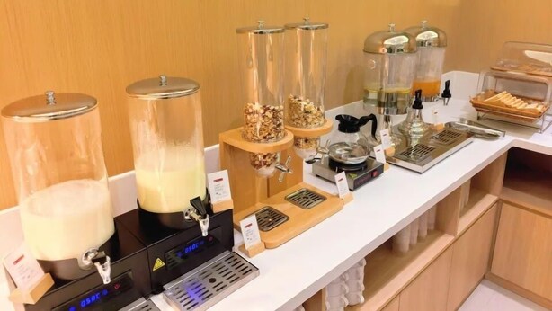A buffet setup with various food items and a coffee station. - Sushi Light Luxury Hotel Xingzhuang (Shanghai)