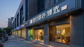A hotel with a modern facade, large glass windows, and a visible reception desk. - Sushi Light Luxury Hotel Xingzhuang (Shanghai)