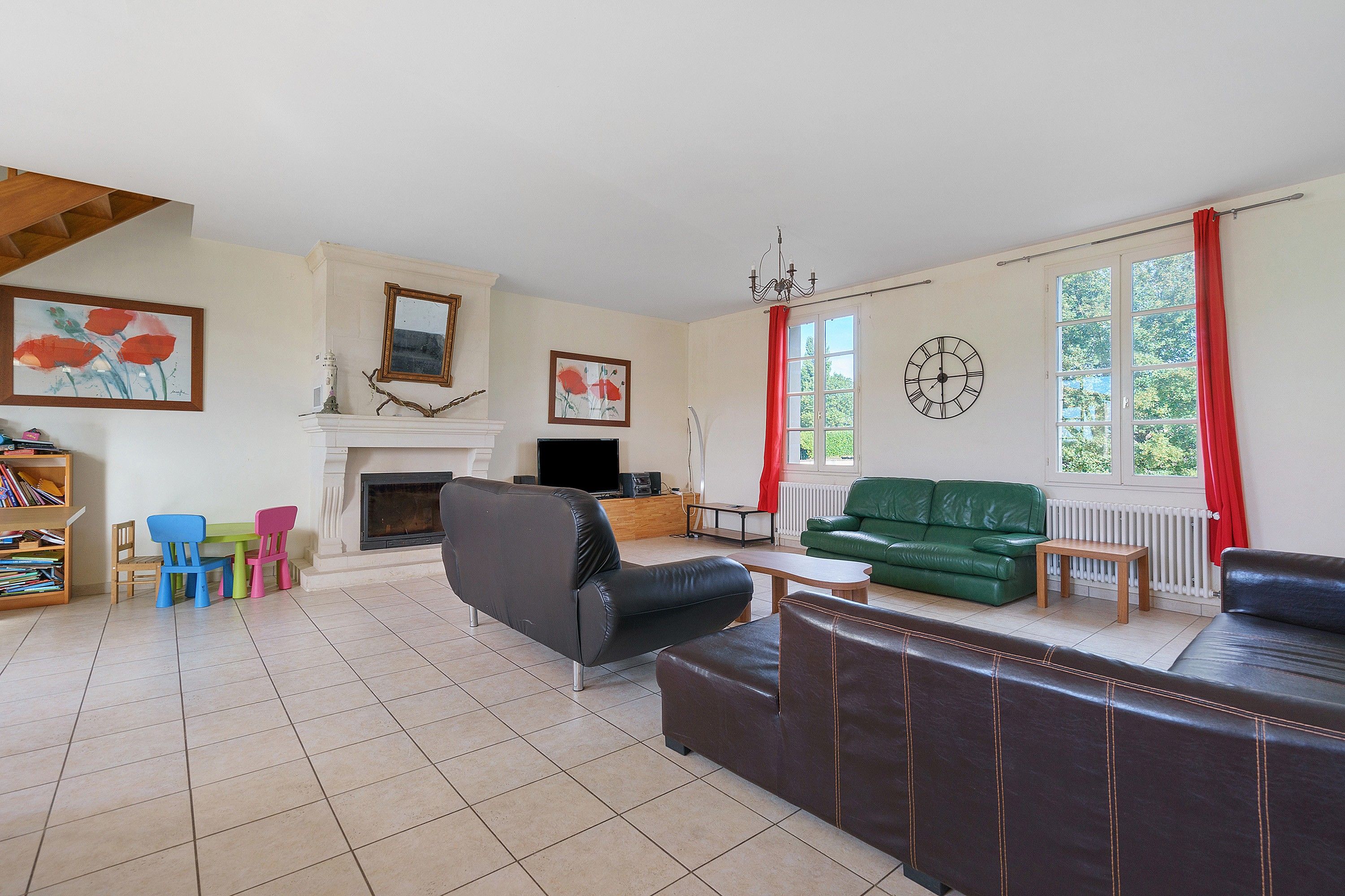 A living room with a fireplace, green sofa, and a television.