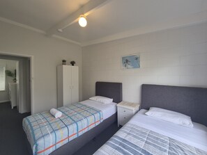 A hotel room with two beds, a wardrobe, a small table, and a wall-mounted picture. - Esperance Little Units 3 (Esperance)