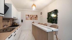 Une cuisine moderne dotée d’une cuisinière intégrée, d’un plan de travail en bois et d’un coin bar avec des tabourets.