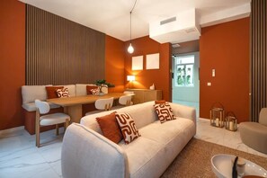 Una sala de estar moderna con un sofá, una mesa de comedor y sillas.