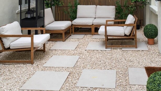 An outdoor seating area with three sofas, a table, and string lights. - La Notre Dame du Sommeil (Bruxelles)