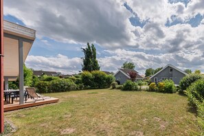 Ein Wohngebiet mit Häusern, einem Rasen und einer überdachten Terrasse.