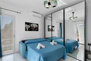 A modern bedroom with two beds, a large mirror, and artwork on the wall. - Apartment 'Rosetta' with Sea View, Wi-Fi and Air Conditioning (Vallebona)