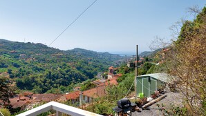 Un quartier résidentiel avec des maisons, un bâtiment écologique et une vue sur un paysage vallonné.