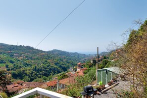 A residential area with houses, a green building, and a view of a hilly landscape. - Apartment 'Rosetta' with Sea View, Wi-Fi and Air Conditioning (Vallebona)