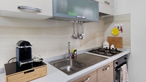 Une cuisine moderne équipée d’un four à micro-ondes, d’une cuisinière et d’un évier intégrés.