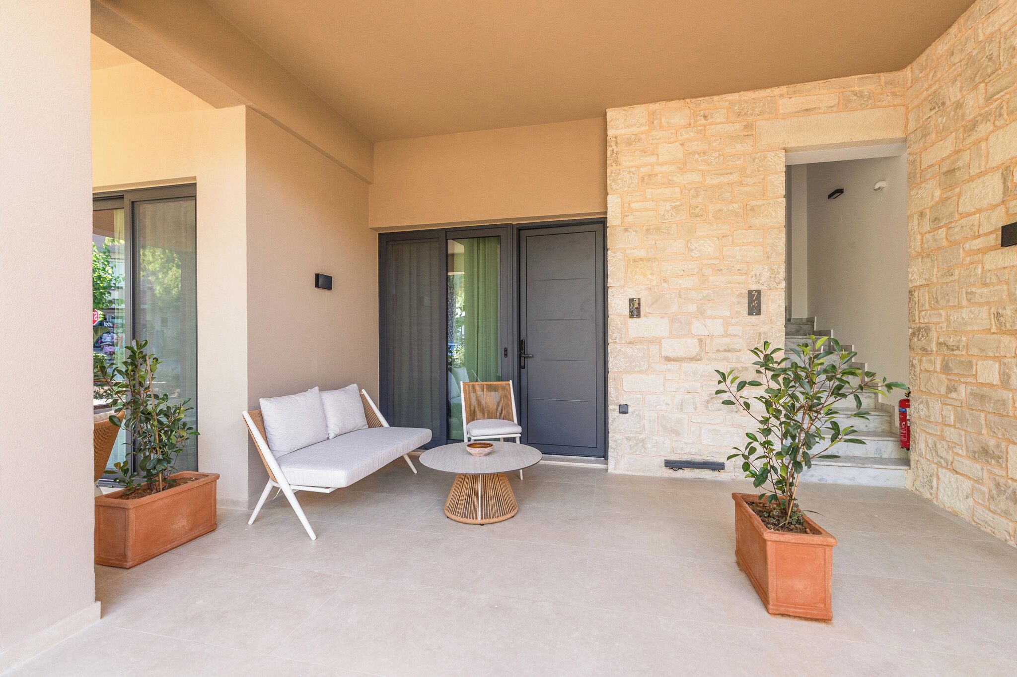 A modern outdoor seating area with a sofa, chairs, and a small table.