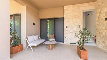 A modern outdoor seating area with a sofa, chairs, and a small table.