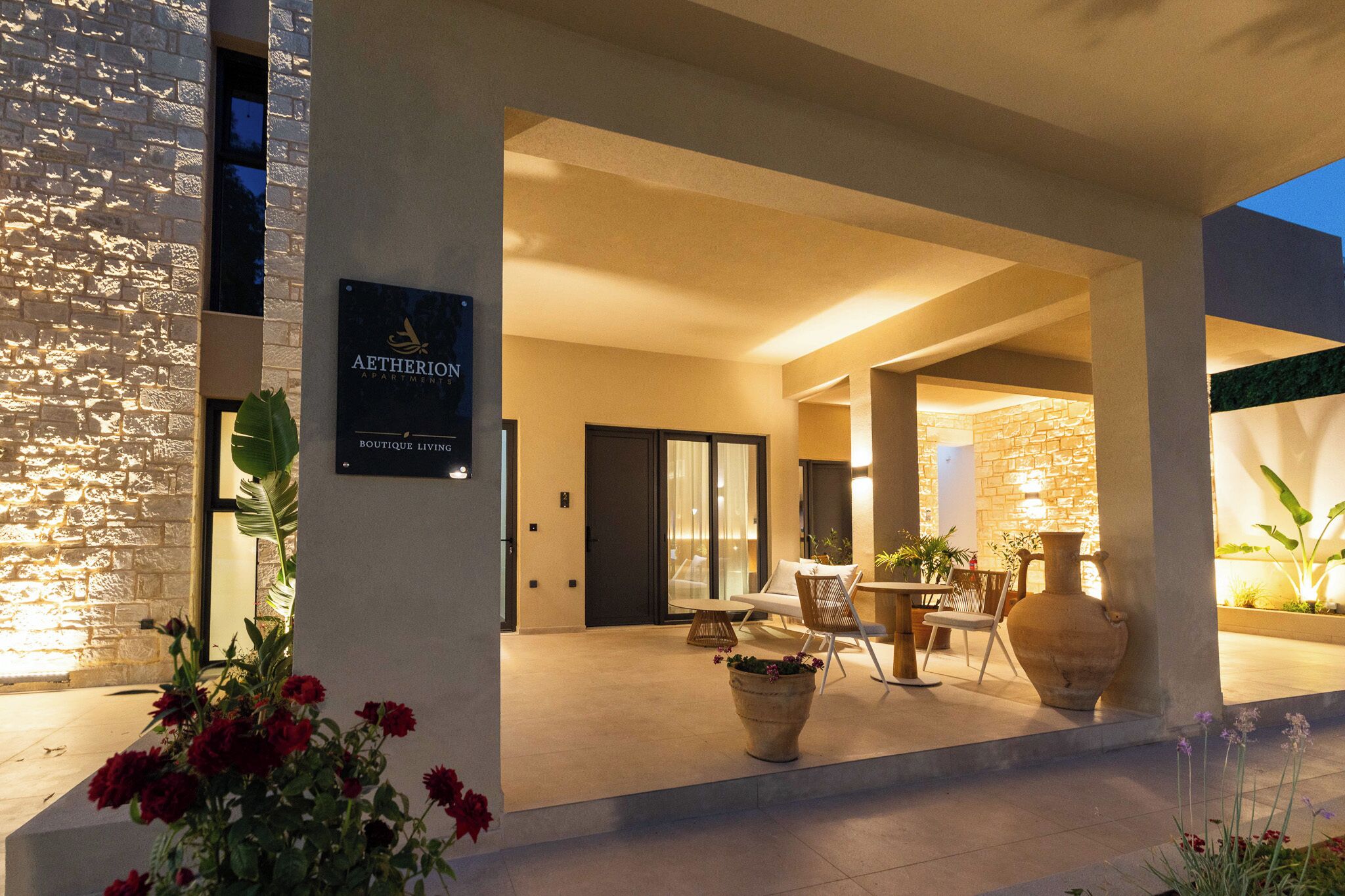 Fachada moderna de un edificio con un cartel que dice 'AETHERION BOUTIQUE LIVING'.