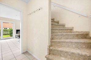 A staircase with a handrail and a landing with a coat rack. - Enjoy a relaxing getaway at the "Küstenzeit SPO" vacation apartment. (Sankt Peter-Ording)
