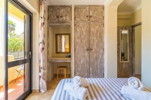A bedroom with a bed, a desk, and a wardrobe. - SEAS THE DAY (Luz)