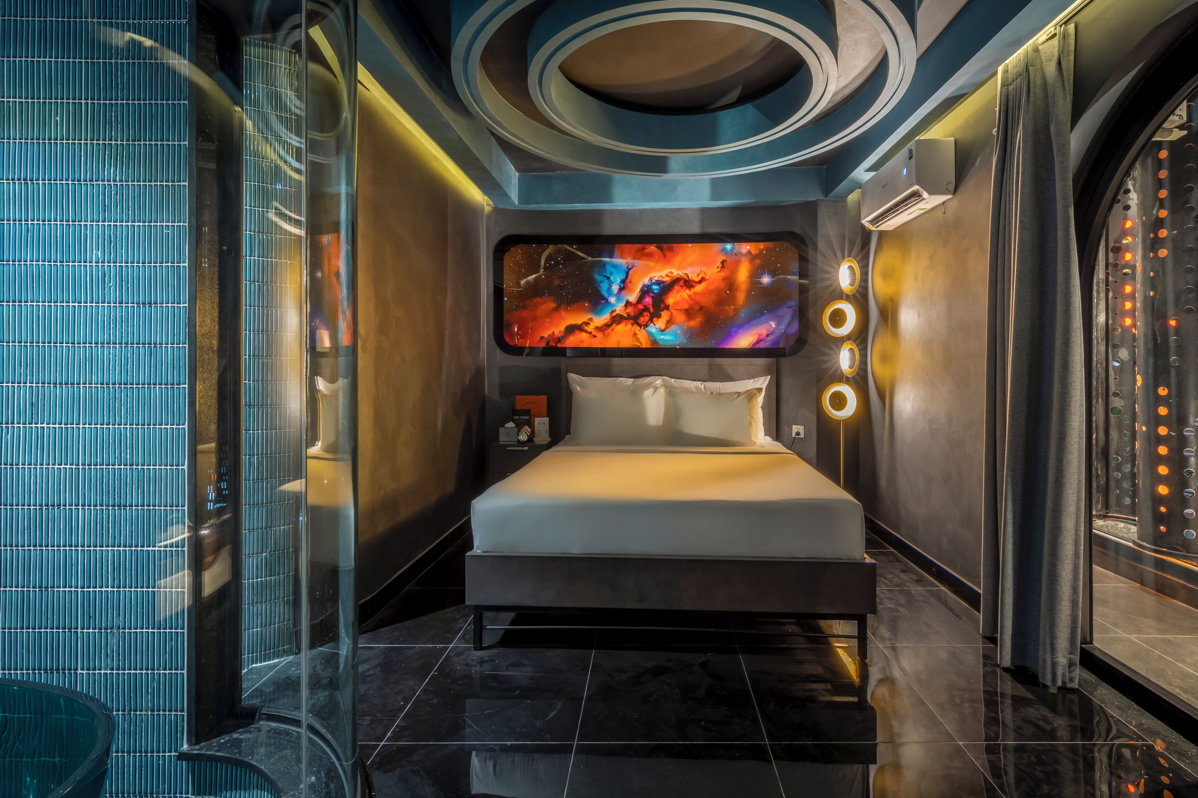 Une chambre à coucher moderne avec un grand lit, un téléviseur fixé au mur et un motif circulaire au plafond.