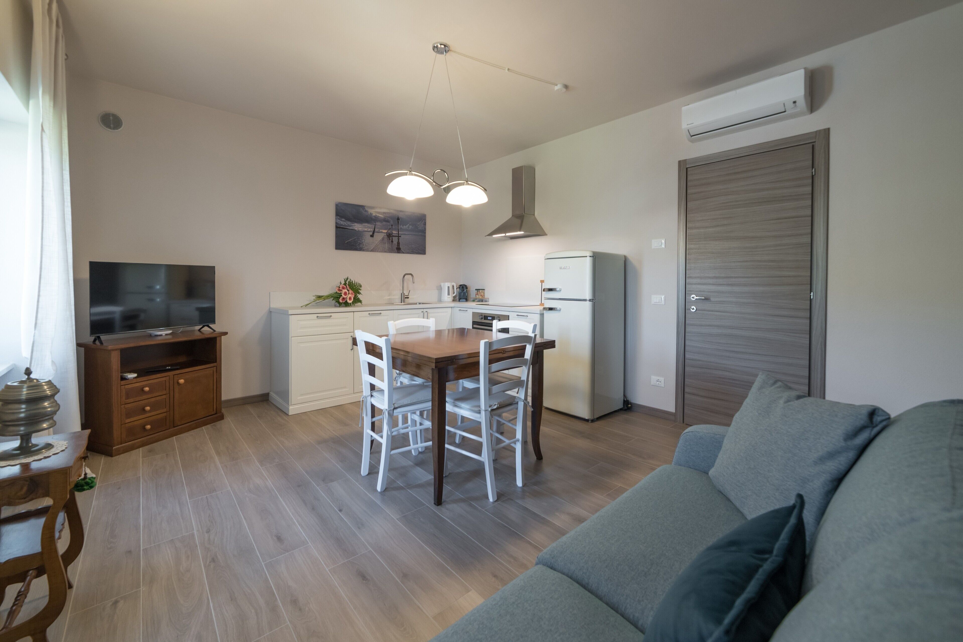 A compact living space with a dining area, kitchenette, and a sofa.