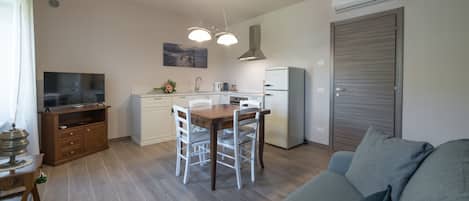 A compact living space with a dining area, kitchenette, and a sofa.