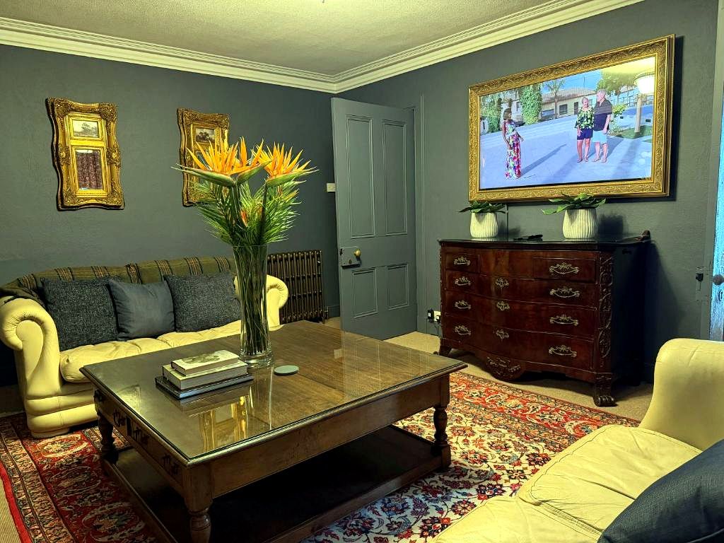 A living room with a sofa, coffee table, and a television.
