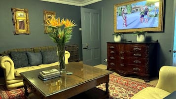 A living room with a sofa, coffee table, and a television.