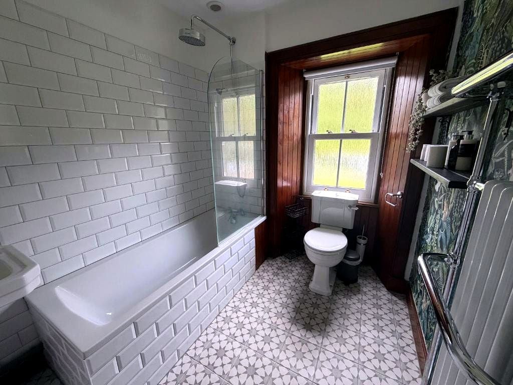 A bathroom with a bathtub, toilet, and shower.