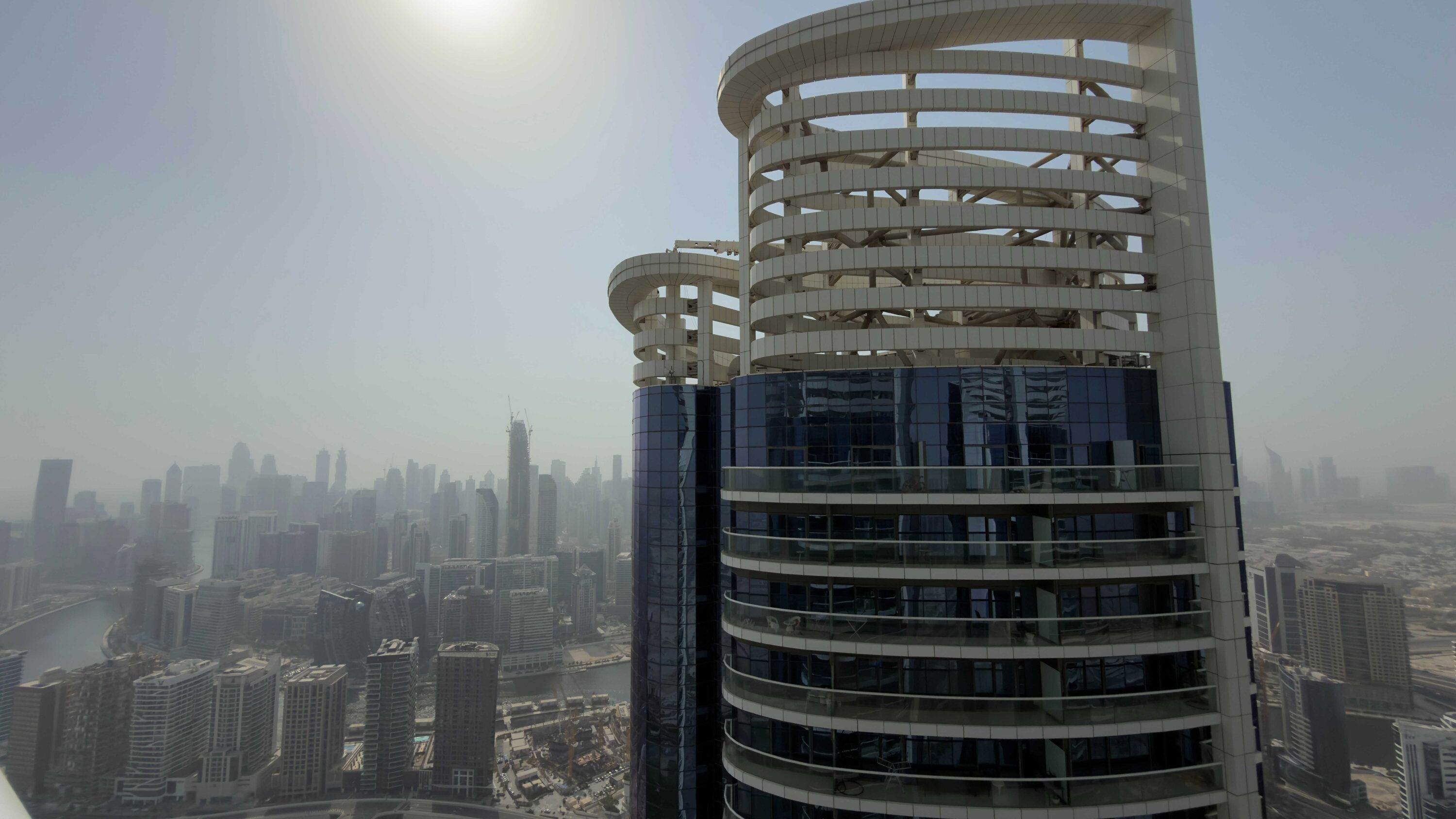 A high-rise building with a unique cylindrical design and multiple balconies.