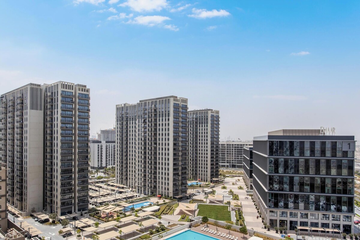 A high-rise residential building complex with multiple apartment buildings, a swimming pool, and a landscaped courtyard.