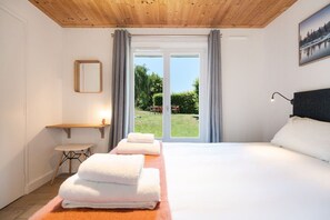 Ein Hotelzimmer mit einem Bett, einem Schreibtisch und Blick auf einen Garten.