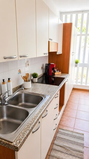 Cafetera o tetera, frigorífico, microondas y placa de cocina