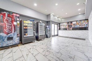 Een nette, moderne lobby met automaten, een pinautomaat en een snackbar.