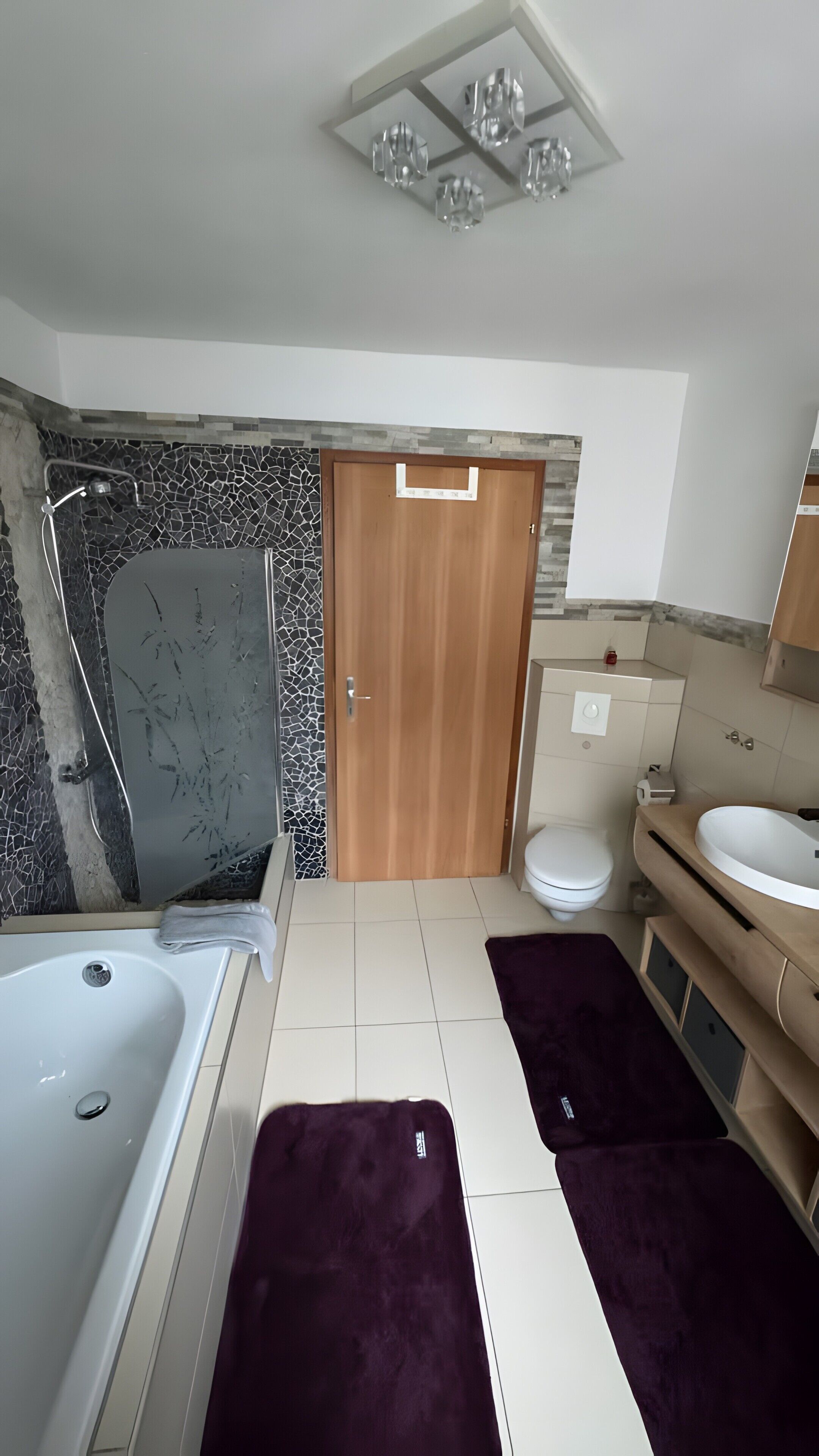 Une salle de bain équipée d’une baignoire, d’une douche, de toilettes et d’un meuble-lavabo.